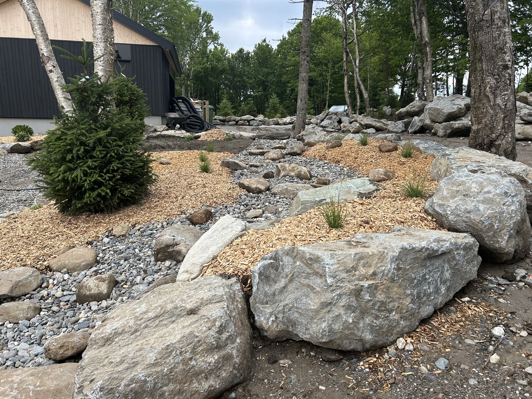 Finition paysagère avec pierres naturelles, paillis et plantations
